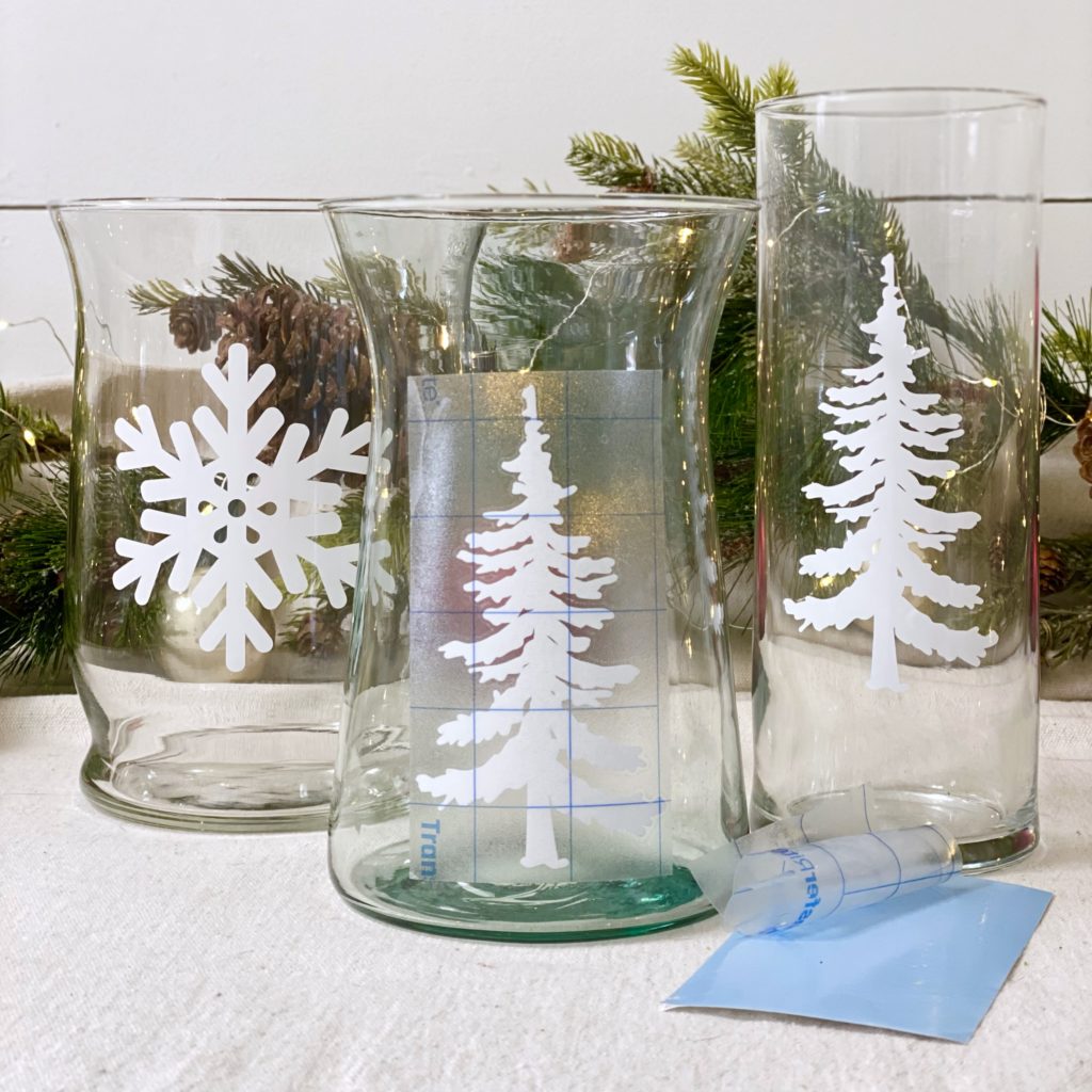 Sticking an evergreen tree decal onto a glass container.