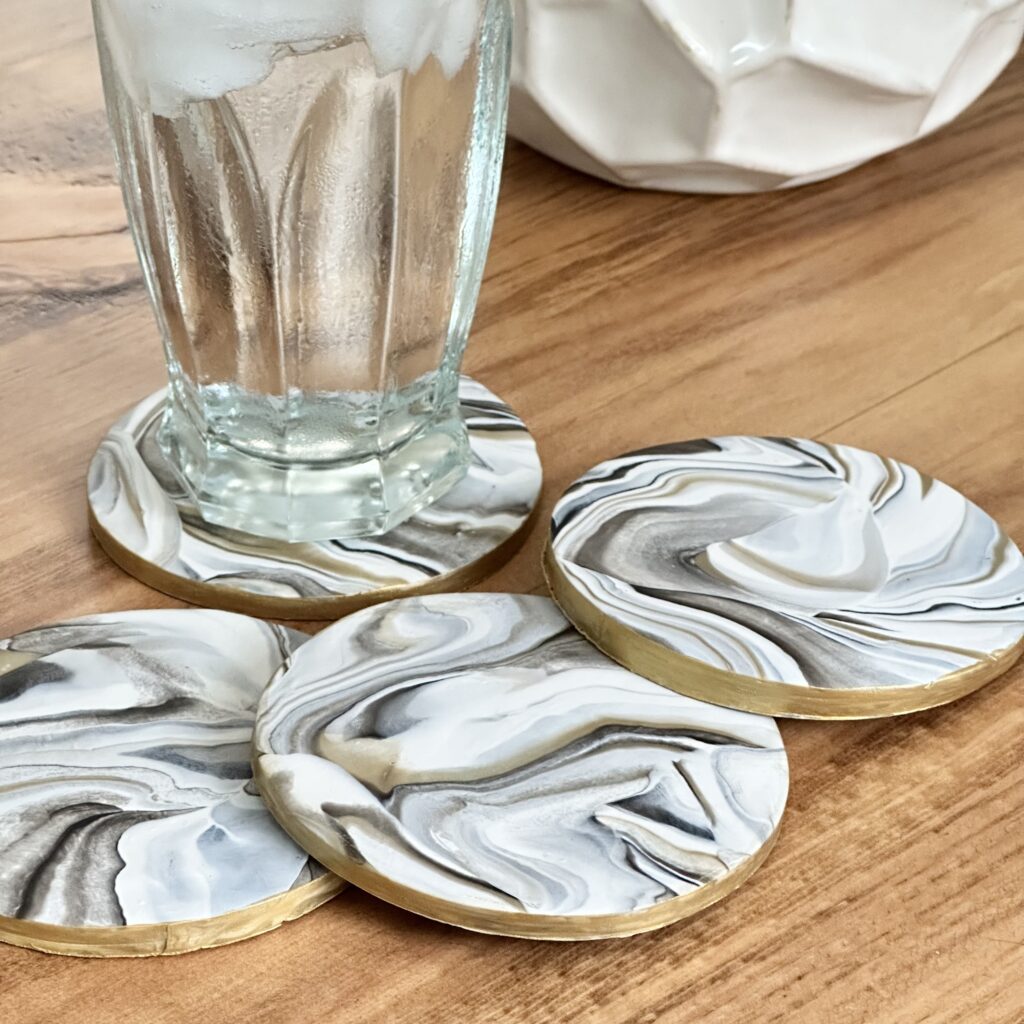 Marbleized Polymer Clay Coasters Pin a coffee table with a glass of water on one of them.