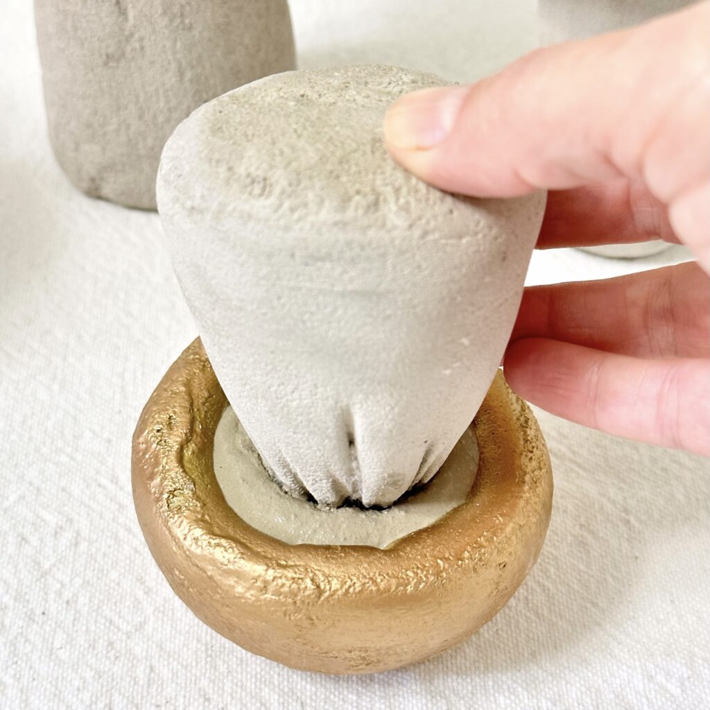 Attaching the concrete mushroom cap to the stem with concrete.