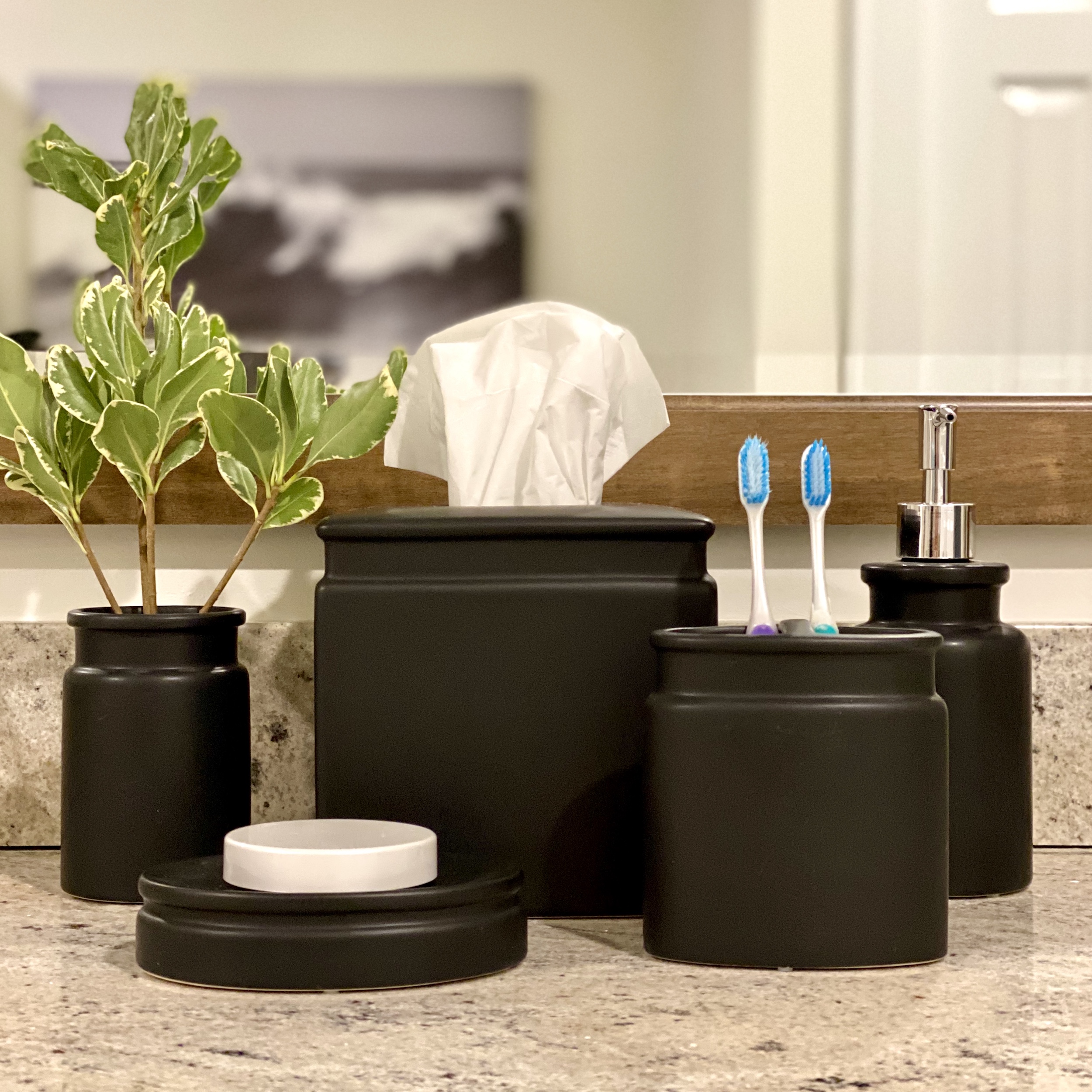 Matte black ceramic 5 piece bathroom vanity set including tissue box, toothbrush holder, lotion dispenser, soap dish, and cup.