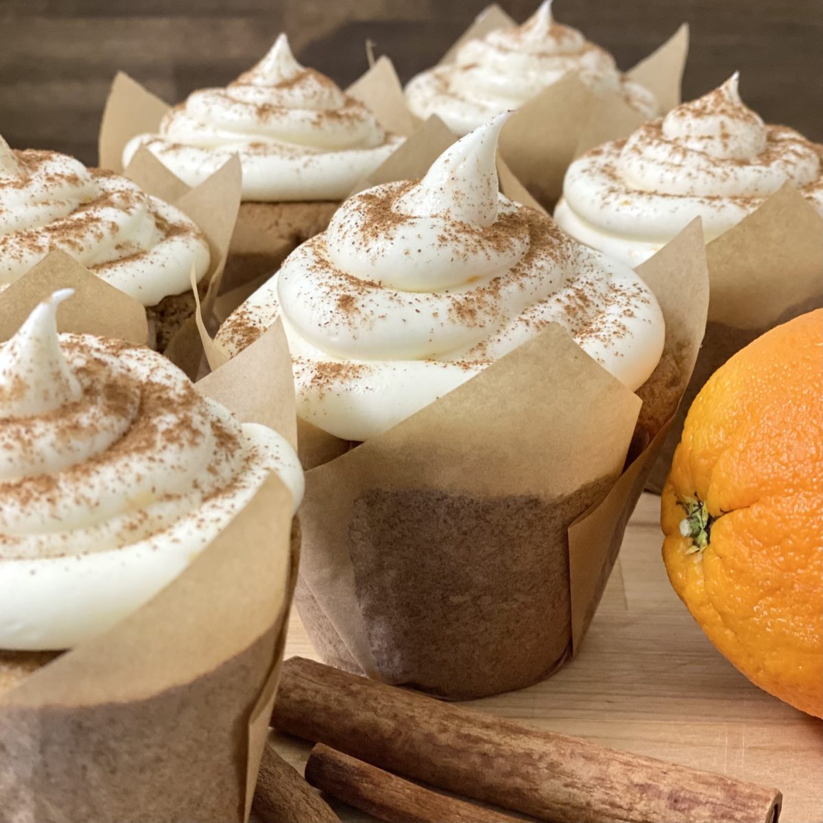 Orange Spice Cupcakes with Orange Cream Cheese Frosting sprinkled with ground cinnamon.