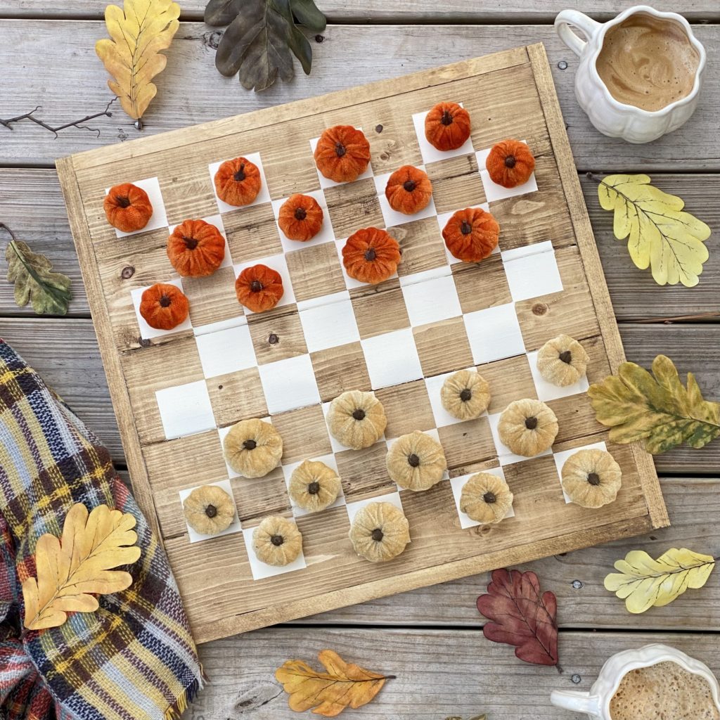 DIY Checker Board all set to play with in fall with little orange and gold pumpkins as checker pieces.